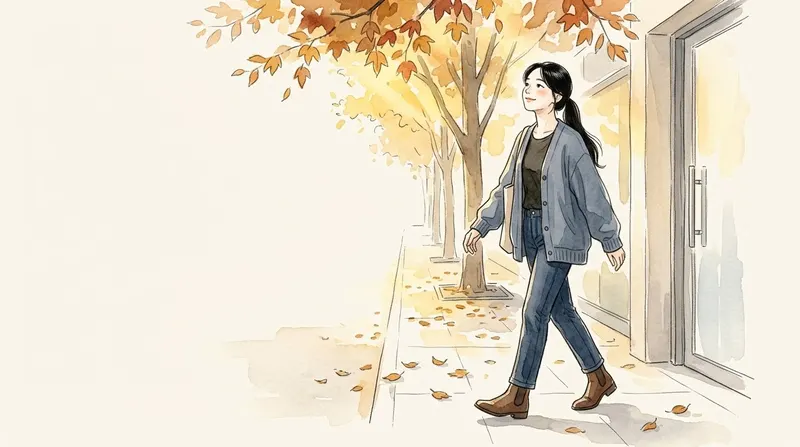 Young woman walking along a leaf-covered sidewalk in autumn light, smiling